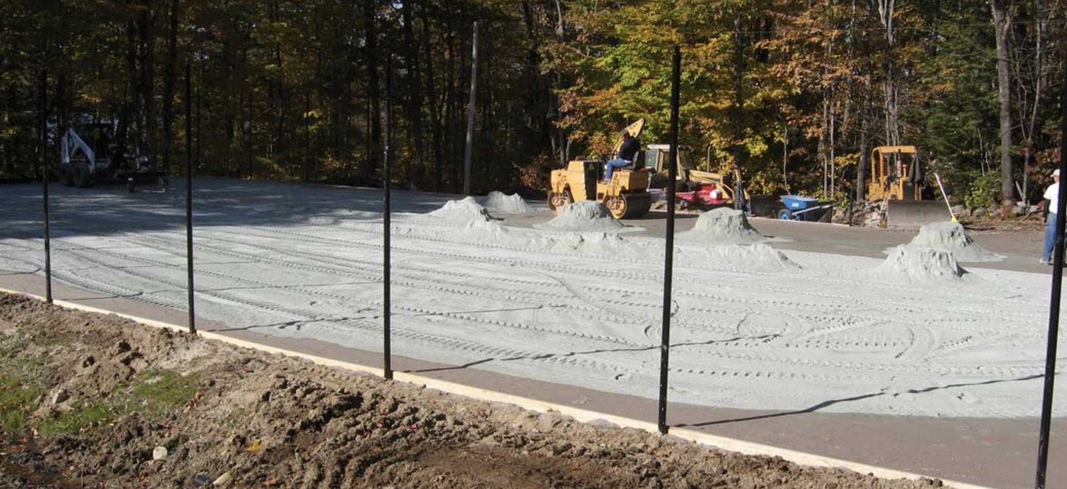 Court construction crew performing fine grading on a new court base